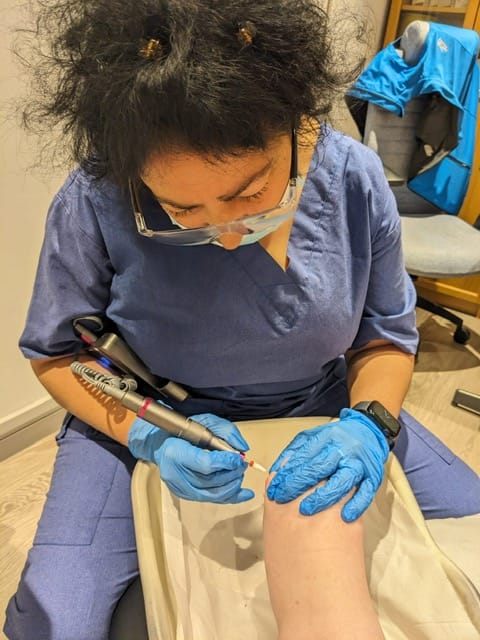 Kam carrying out a foot treatment for a client
